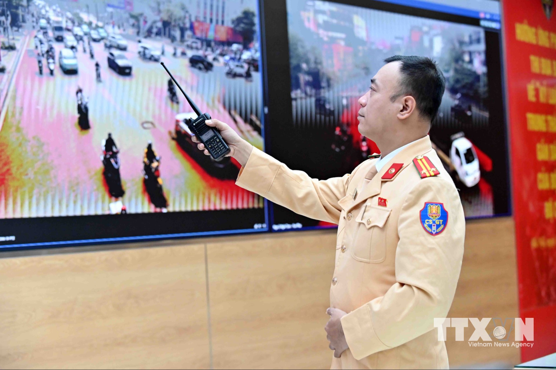 Trung tá Nguyễn Văn Khương, Phó Đội trưởng Đội Chỉ huy giao thông và Điều khiển đèn tín hiệu giao thông trực tiếp chỉ huy, phân luồng, điều tiết giao thông và cảnh báo sớm các điểm ùn tắc qua hệ thống Camera AI. (Ảnh: Phạm Kiên/TTXVN)